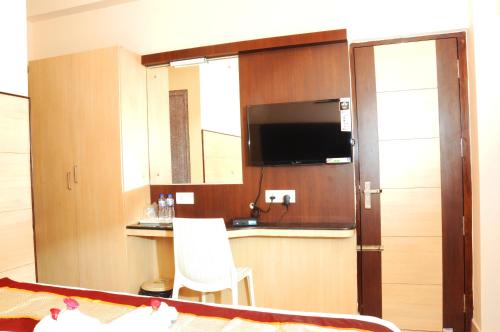 a room with a kitchen with a sink and a television at Sai Budget Hotel Chennai Airport in Chennai