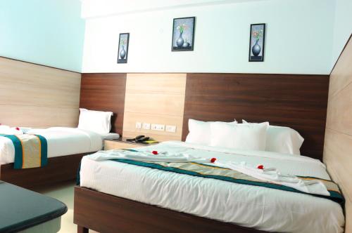 a hotel room with two beds with roses on them at Sai Budget Hotel Chennai Airport in Chennai