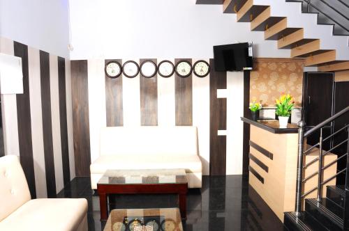 - un salon avec un canapé et une télévision dans l'établissement Sai Budget Hotel Chennai Airport, à Chennai