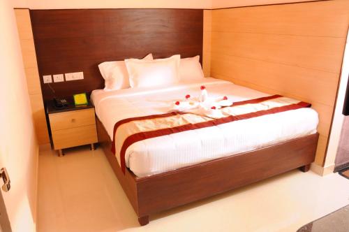 a bedroom with a bed with two stuffed animals on it at Sai Budget Hotel Chennai Airport in Chennai