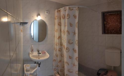 ein Bad mit einem Duschvorhang und einem Waschbecken in der Unterkunft BB House in Balatonboglár