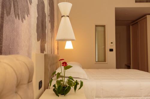 a bedroom with a bed and a plant on a table at Regina City Hotel & SPA in Vlorë