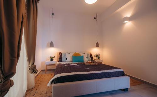 a bedroom with a bed and two pendant lights at Iviskos Lux in Apollonia