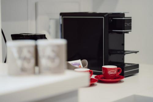 a kitchen counter with two cups and a microwave at Vittoria Suite in Campobasso