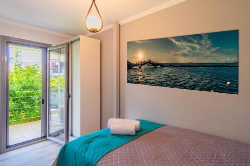 a bedroom with a bed and a painting on the wall at Dion apartment in Lygia