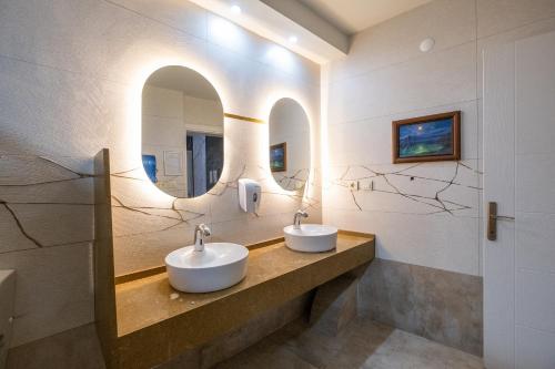 2 lavabos en un baño con espejo en Hotel Sunday Beach, en Kusadasi