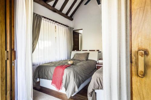 a small bedroom with a bed and a window at DK Luxury Ocean Front Villa - Adults Only in Holbox Island