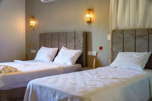 1 dormitorio con 2 camas con sábanas blancas en 7 Oda Söğüt, en Marmaris