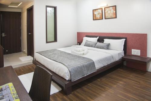a bedroom with a large bed with a large white bed sidx sidx sidx at Hotel Pearls in Aurangabad