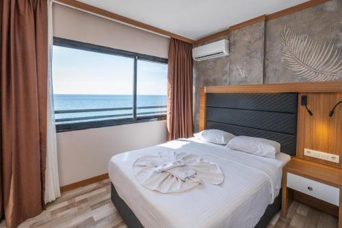 a bedroom with a bed with a view of the ocean at Hotel Sunday Beach in Kusadası