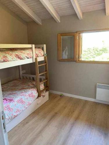 ein Zimmer mit zwei Etagenbetten und einem Fenster in der Unterkunft Adosada en Llo in Llo