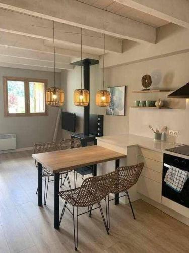 eine Küche mit einem Holztisch und Stühlen in der Unterkunft Adosada en Llo in Llo