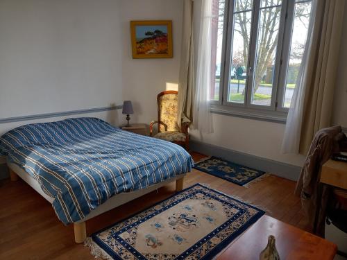 1 dormitorio con cama, ventana y 2 alfombras en Le gite du port 2 chambres, en Lere