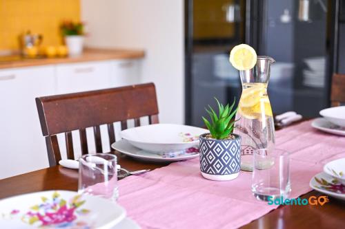 einen Tisch mit einer Vase mit einer Zitrone drauf in der Unterkunft Appartamenti Jolly by SalentoGo in Torre Lapillo