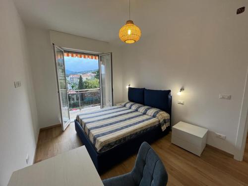um quarto com uma cama e uma grande janela em Il giardino segreto em Pietra Ligure