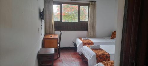 a small room with two beds and a window at Hotel MAXIRUMA - Villa TAMAUKA in Iza