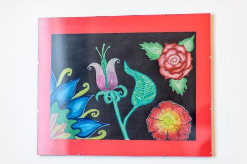a painting of flowers in a red frame at Hostel Globo in Šibenik
