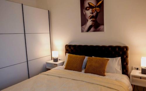 a bedroom with a bed with two lamps and a mirror at Apartment Leona in Kraljevo