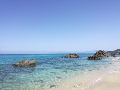 a beach with some rocks in the water at Residenza Villa Spagnola in Parghelia