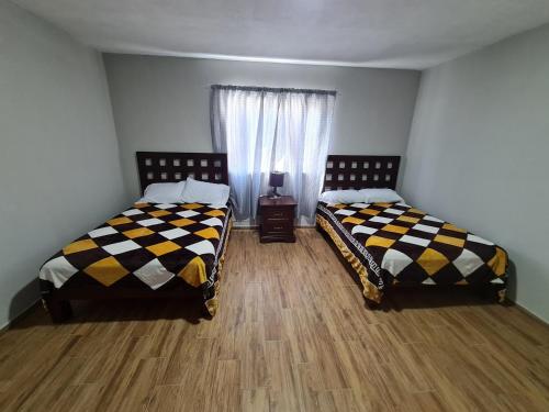 due letti uno accanto all'altro in una stanza di Hermosa casa ubicada en zona centro, andares y estadio a Guadalajara