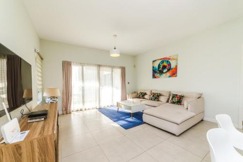 a living room with a couch and a tv at Beachcove Apartment 9 in Pereybere in Pereybere