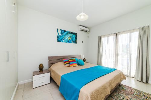 a bedroom with a bed and a large window at Beachcove Apartment 9 in Pereybere in Pereybere