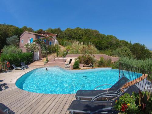 - une piscine avec des chaises sur une terrasse en bois dans l'établissement Maison & Piscine Privée Vue Mer panoramique très calme indépendant, à Porto-Vecchio