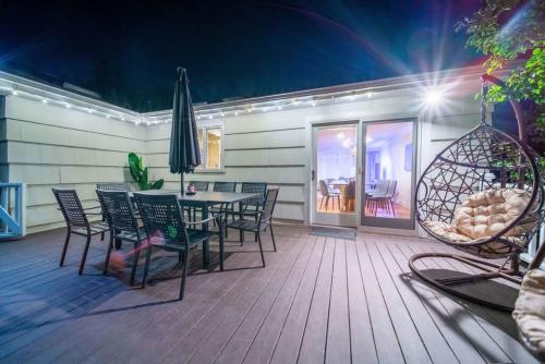 un patio con mesa y sillas en una terraza en New Beach Home near Stamford Downtown/Shippan, en Stamford