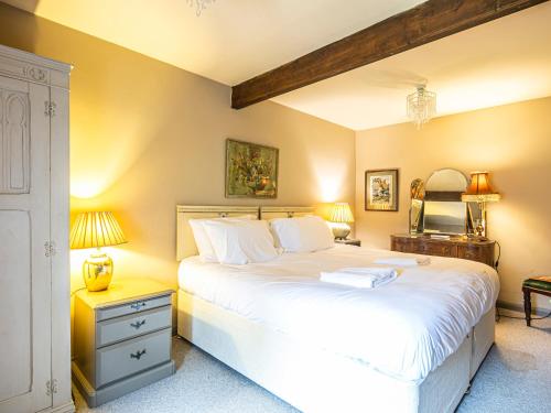 a bedroom with a large white bed and two lamps at Pippinwell in Bakewell