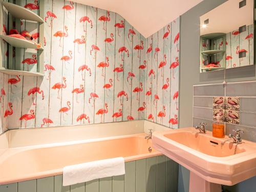 a bathroom with a pink tub and a sink at Pippinwell in Bakewell
