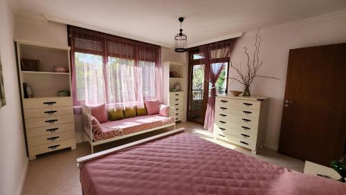 a bedroom with a pink bed and a window at Nevena Summer Apartment by Santa Marina Sozopol in Sozopol
