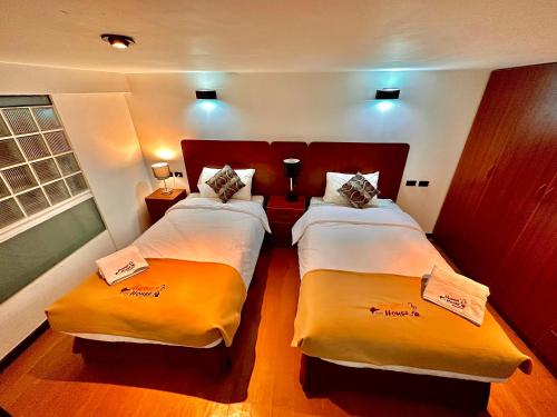 um quarto de hotel com duas camas e uma janela em Mama's House em Cusco