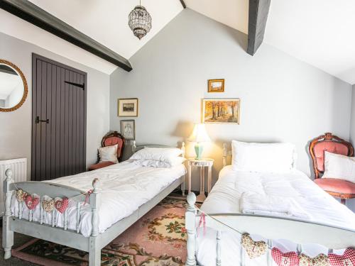 two beds in a room with white walls at Rabbit Hut in Bakewell