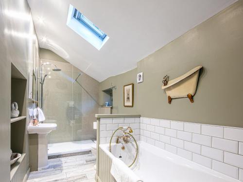 a bathroom with a shower and a tub and a sink at Rabbit Hut in Bakewell