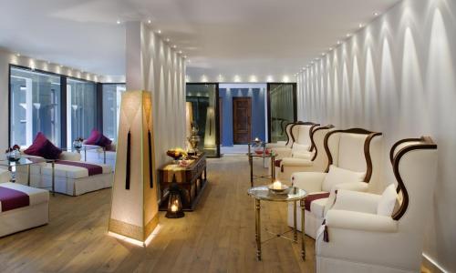 a living room with white couches and tables at Jumeirah Zabeel Saray Dubai in Dubai