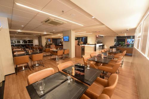 a restaurant with tables and chairs and a bar at ibis Sao Luis in São Luís