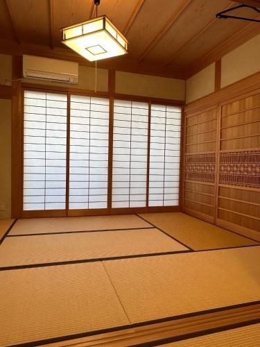 an empty room with doors and a chandelier at Curfew by midnight Guesthouse Tosa Hanare - Vacation STAY 14263 in Kochi