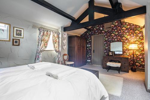 a bedroom with a large white bed in a room at Slipper Lo in Bakewell