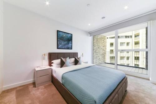 um quarto com uma cama grande e uma janela grande em Stunning Zone 1 Luxury Brand New 2 Bed Apartment em Londres