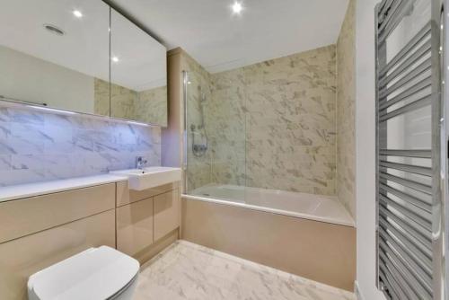 uma casa de banho com uma banheira, um WC e um lavatório. em Stunning Zone 1 Luxury Brand New 2 Bed Apartment em Londres
