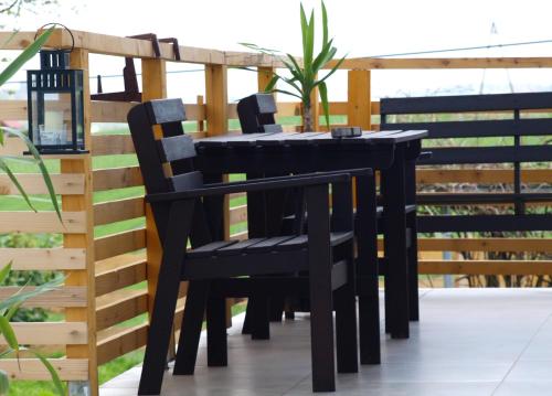 a black table and chairs on a balcony at Panorama Racławicka Domek Willa Basen Agroturystyka in Janowiczki