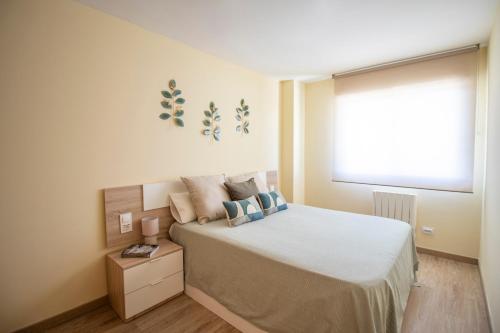 Un dormitorio con una cama grande y una ventana en Aqua - Apartamento a 250m playa, en La Pineda