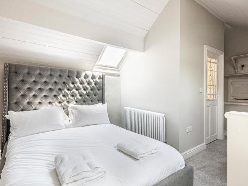 a bedroom with a large white bed with two towels on it at The Artists Loft in Bakewell