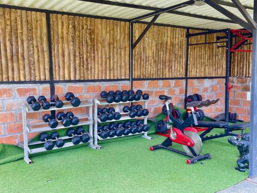 a gym with dumbbells and fitness equipment in a brick wall at Buho Cabaña Santa Elena in Santa Elena