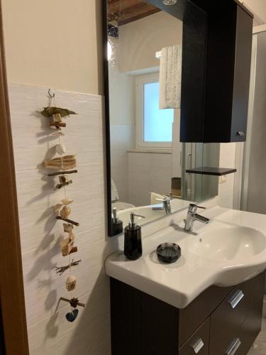 Al Vecchio Platano guest house في بيتيجليانو: حمام مع حوض ومرآة