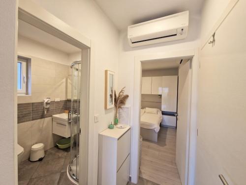 een badkamer met een douche, een wastafel en een toilet bij Apartments Nina in Rab