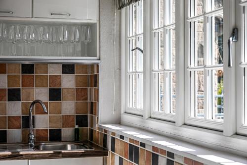 eine Küche mit zwei Fenstern und einem Waschbecken in der Unterkunft The Belle in Bakewell