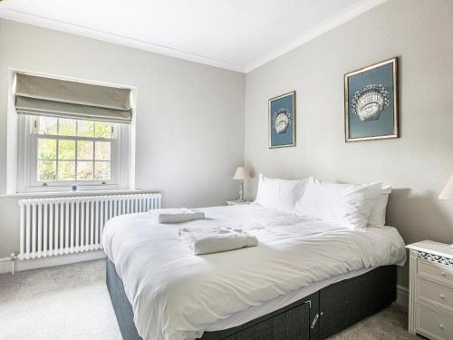 ein großes weißes Bett in einem Schlafzimmer mit Fenster in der Unterkunft The Belle in Bakewell
