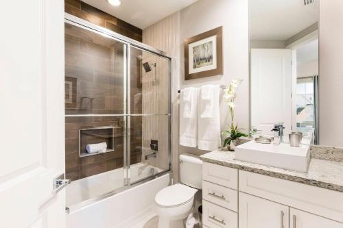 een badkamer met een toilet, een douche en een wastafel bij 5 Suites DREAM House 5 min to Disney in Orlando