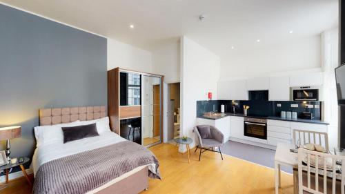 Trueman Street Apartments في ليفربول: غرفة نوم بسرير ومكتب ومطبخ